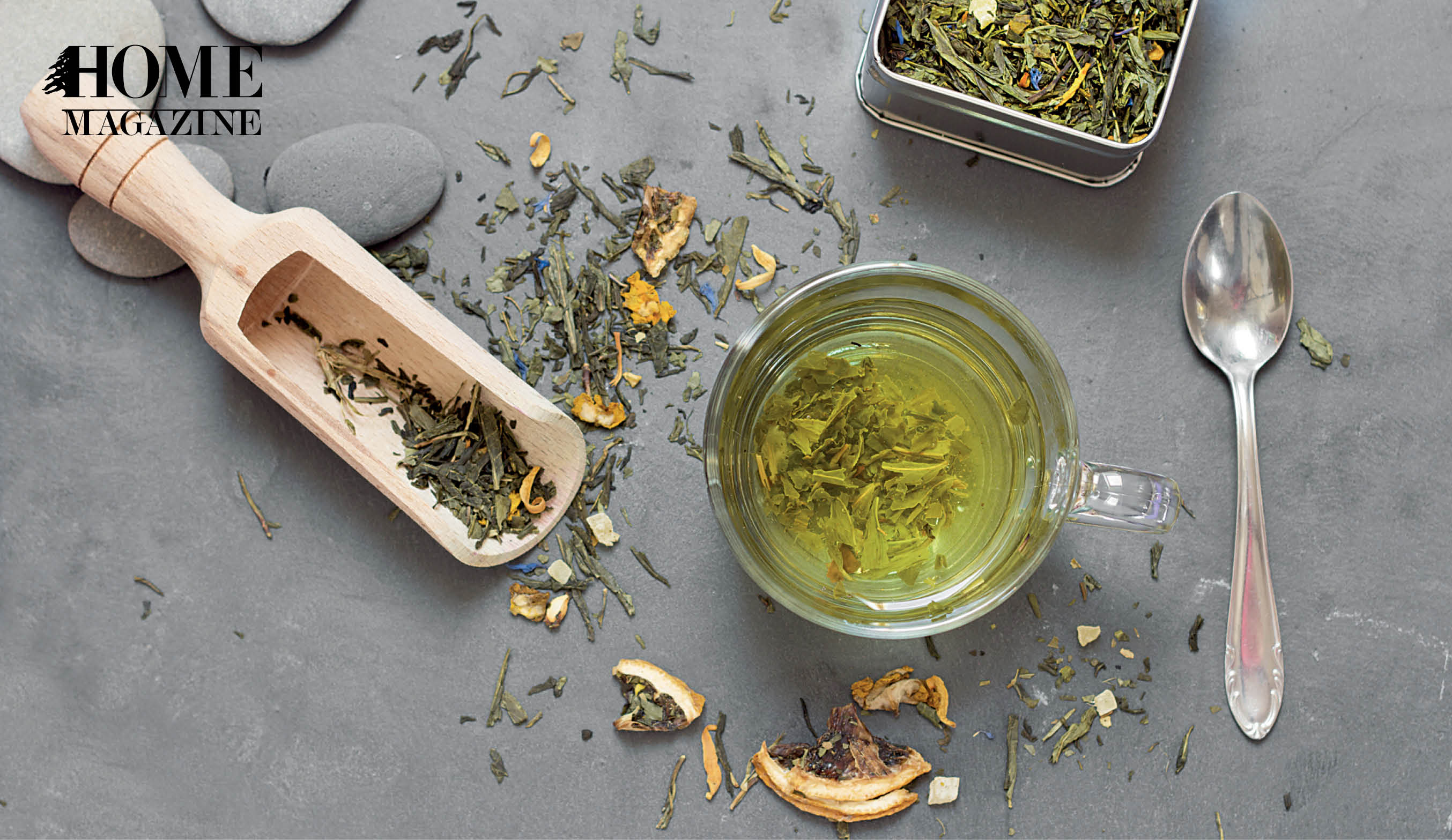 Green tea herbs, fluid green tea in cup, and spoon