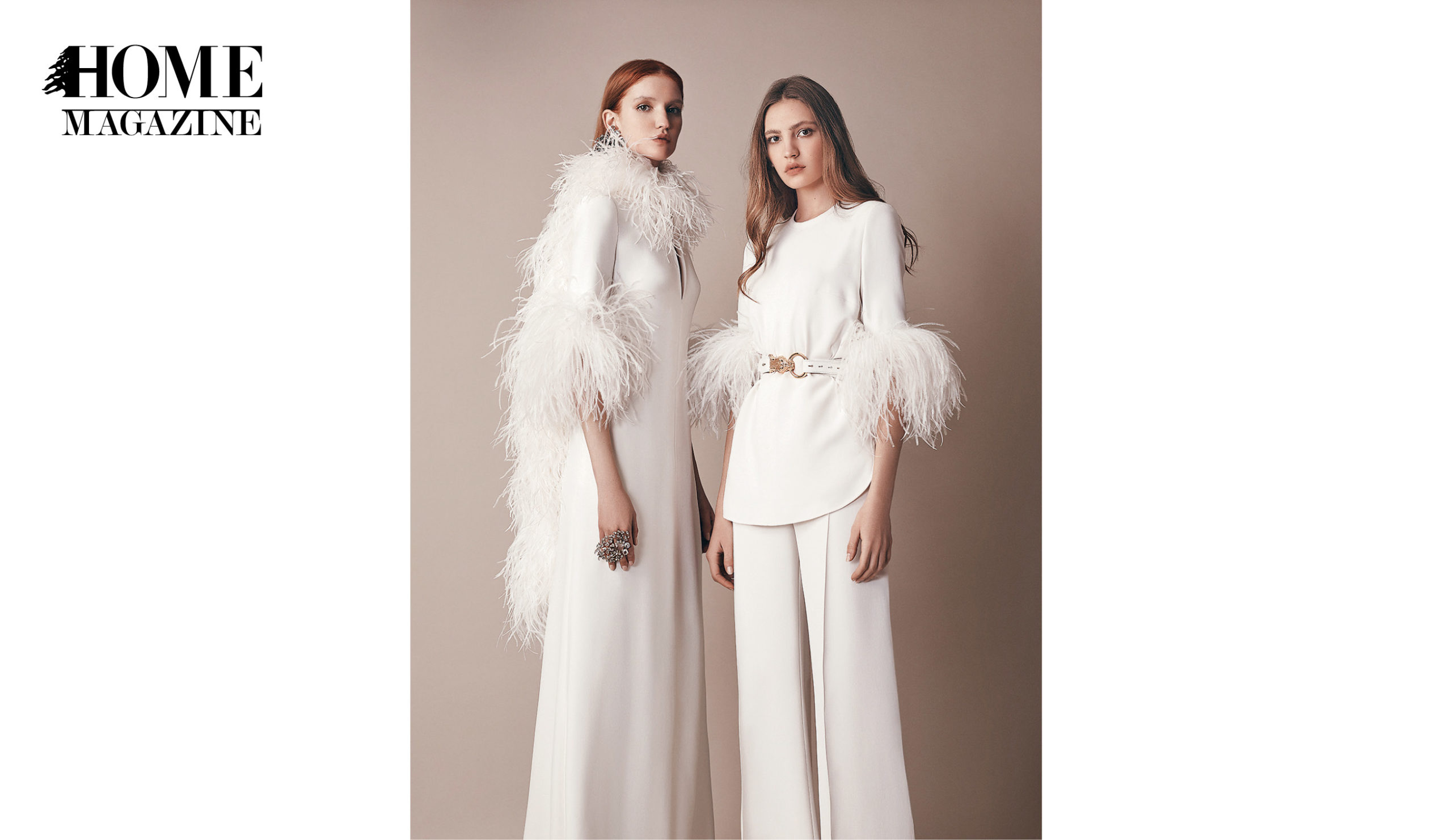 Two models wearing all white ensemble with feathers