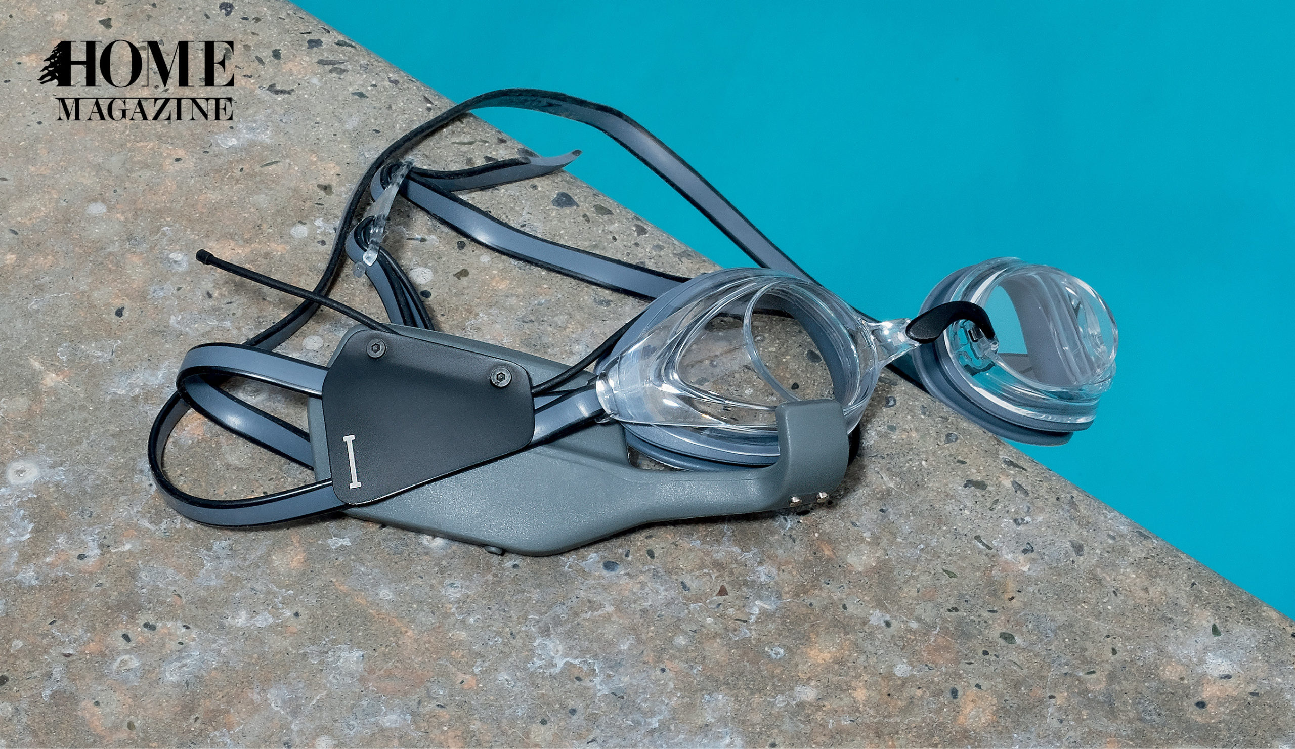 Grey swimming goggles of a pool's edge