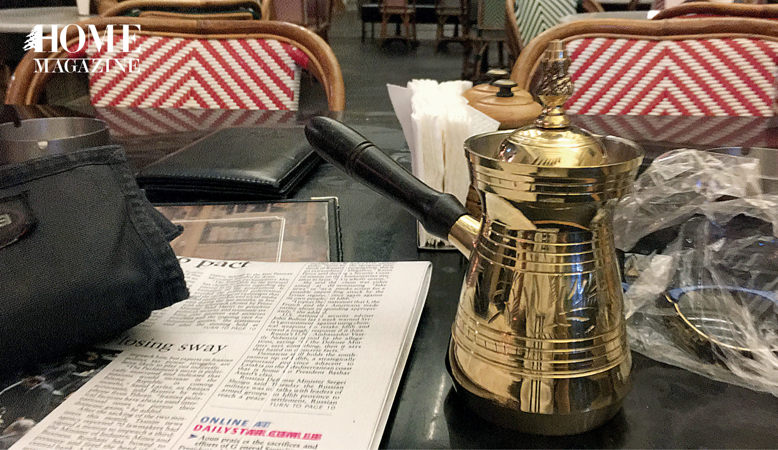A newspaper, napkins and a coffee boiler on a table