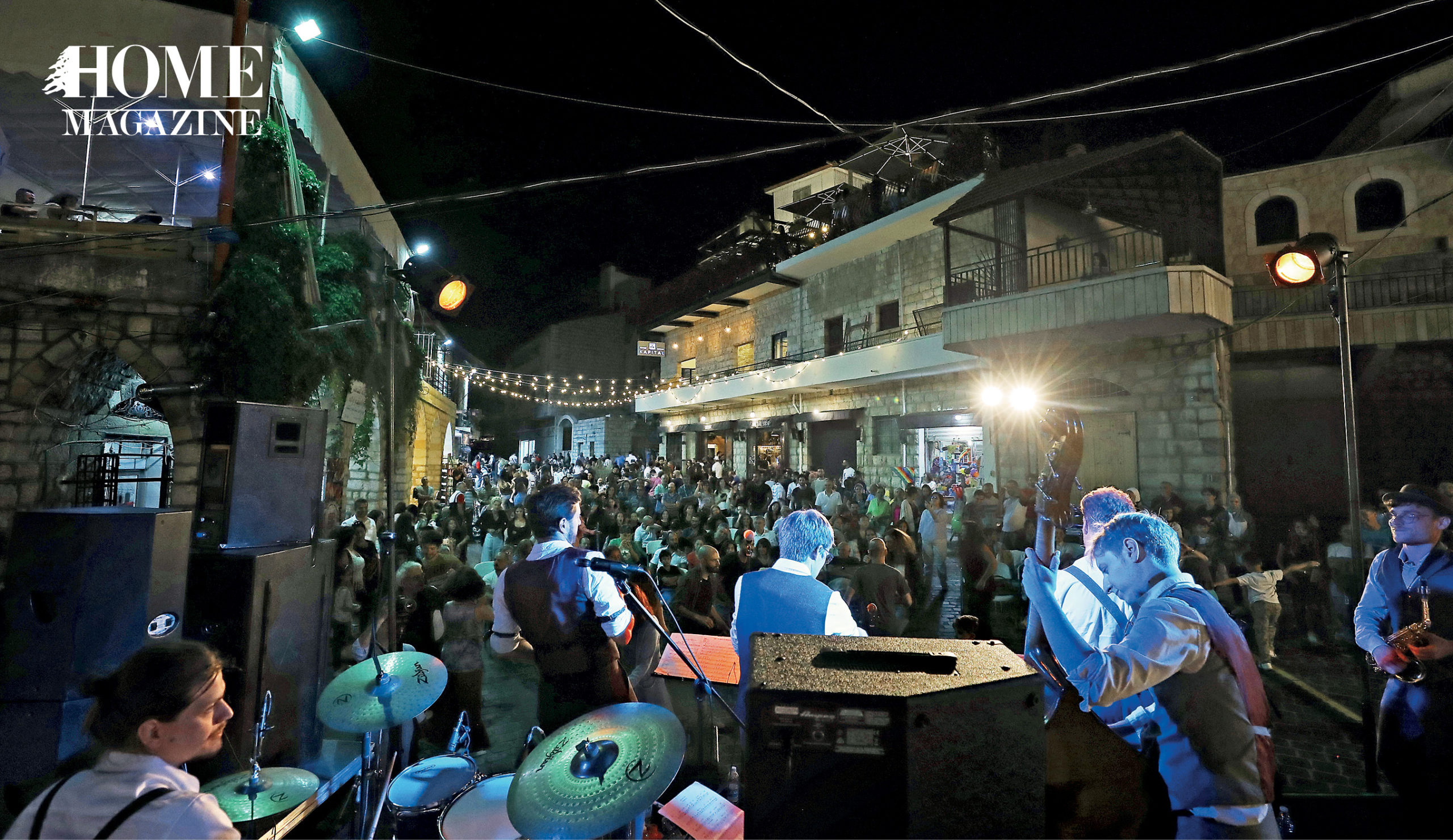 Band performing with crowd amidst buildings and lighting